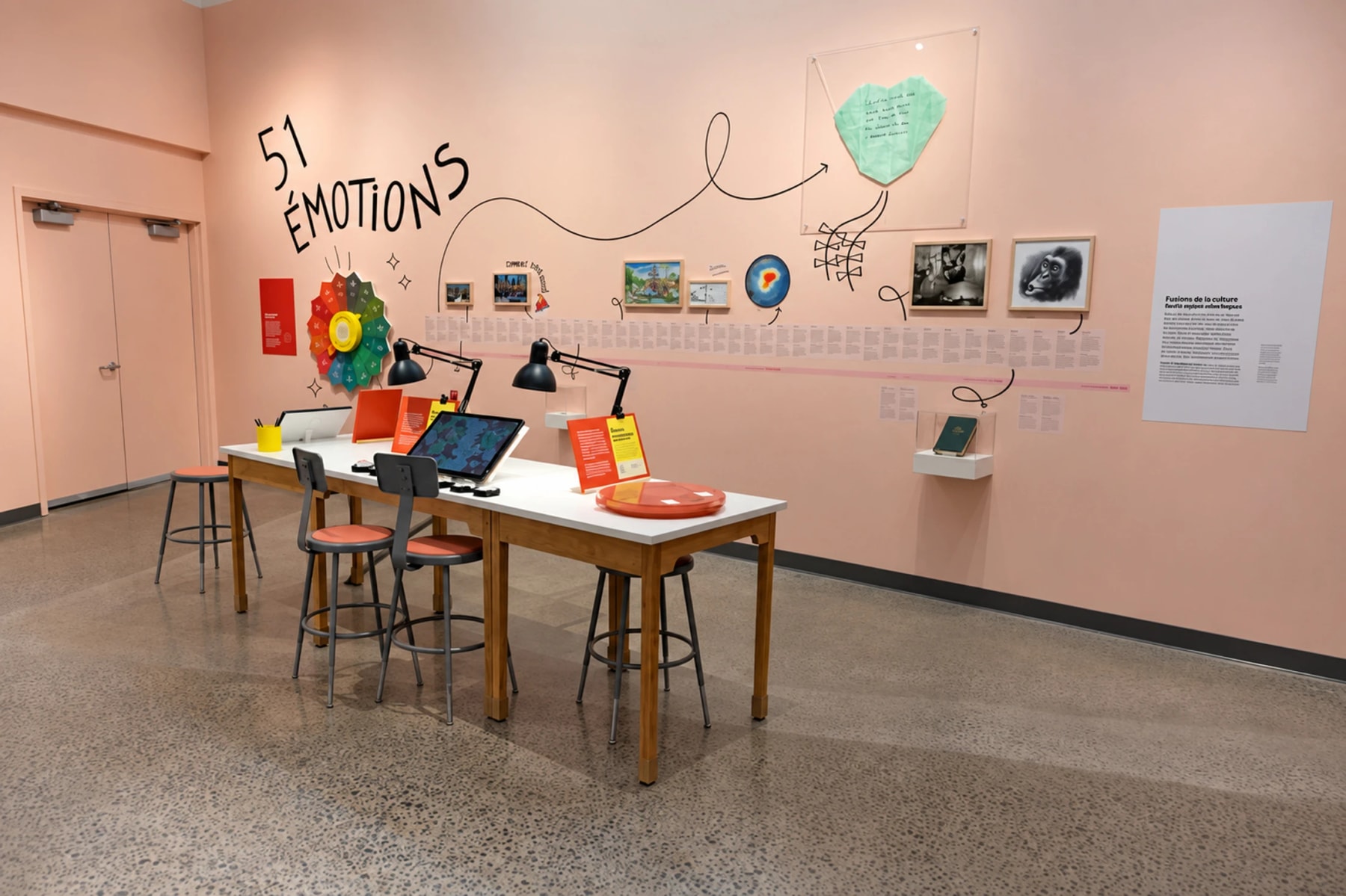 Activity tables and illustrated displays in a pink exhibition room about emotions.