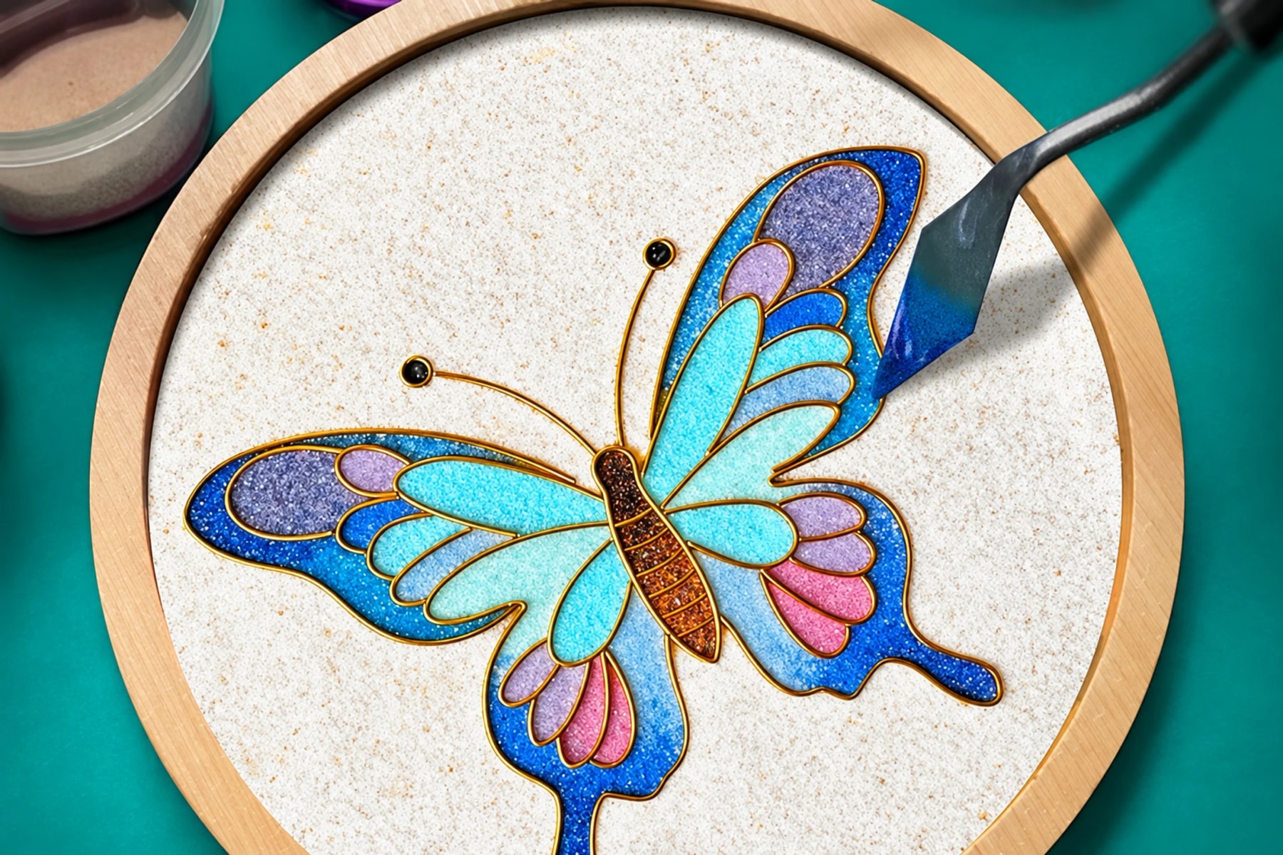 Un outil remplit un motif de papillon bleu et violet avec de la matière colorée.