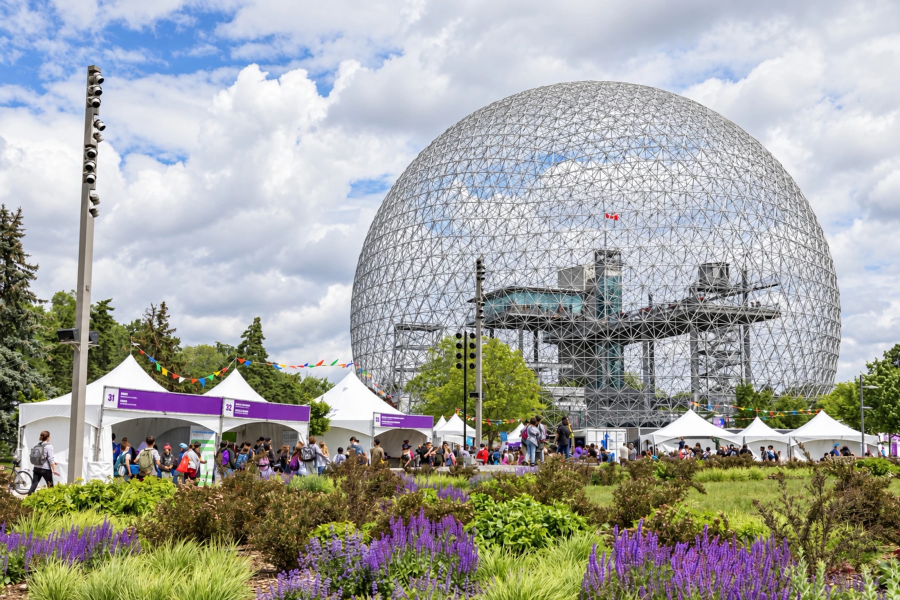 Des tentes de festival et des visiteurs au pied du dôme de la Biosphère.