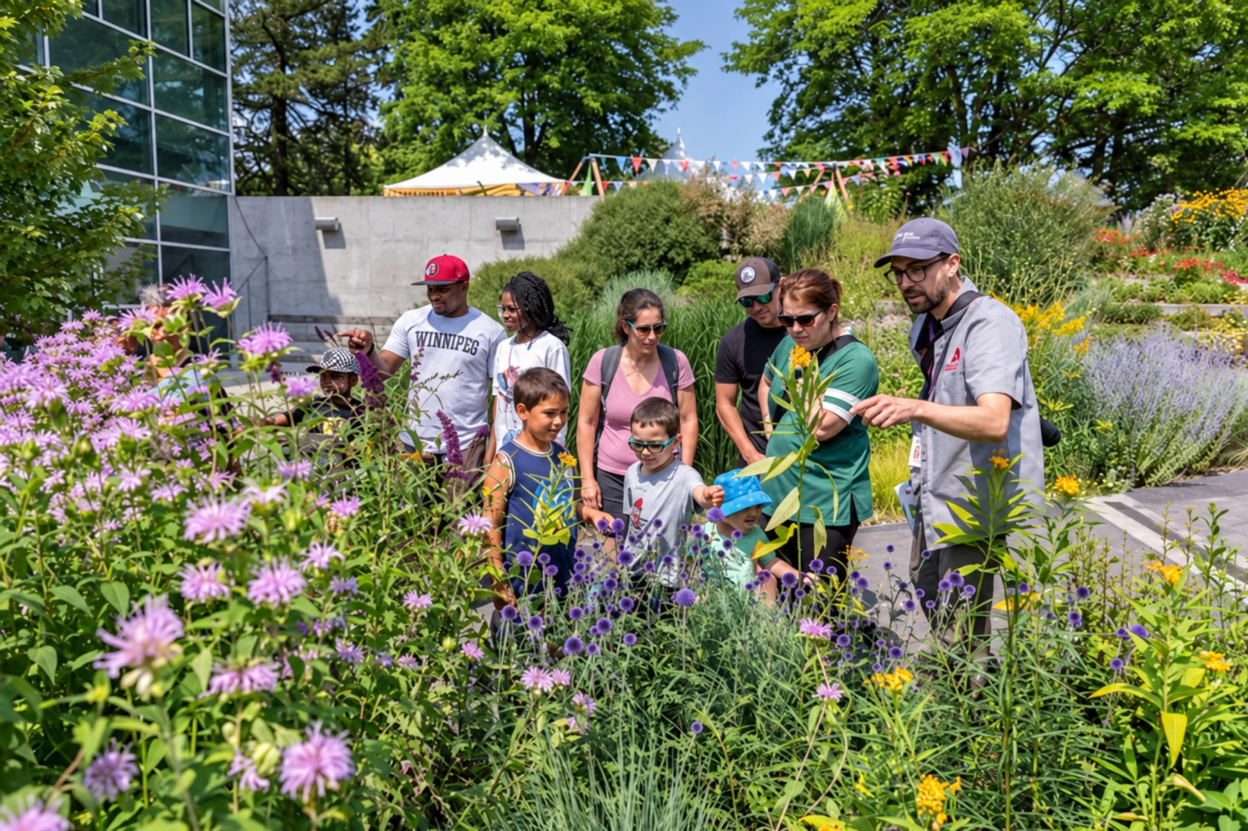A guide shows flowering garden plants to a group of adults and children.