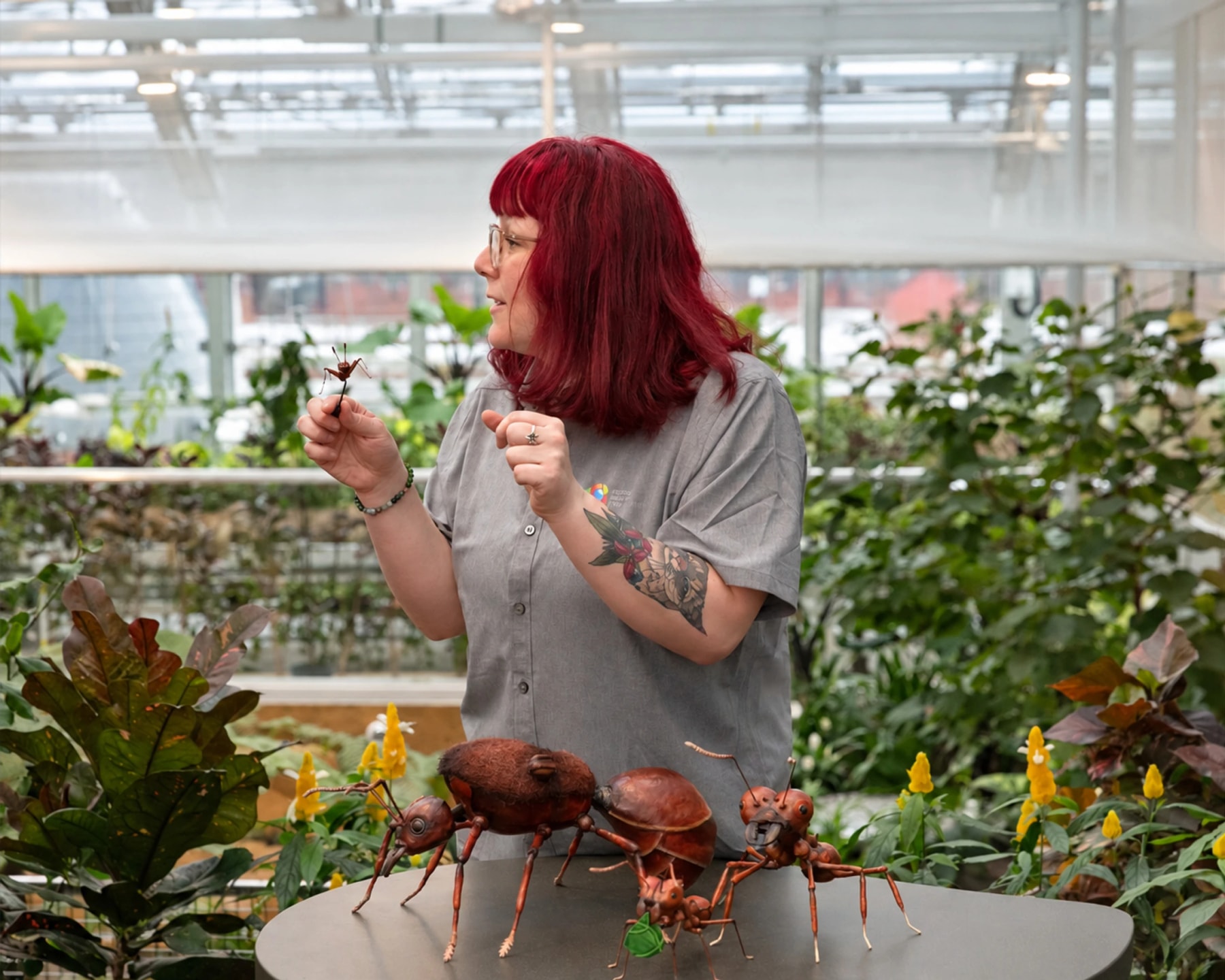 An Insectarium presenter demonstrates beside oversized ant models.